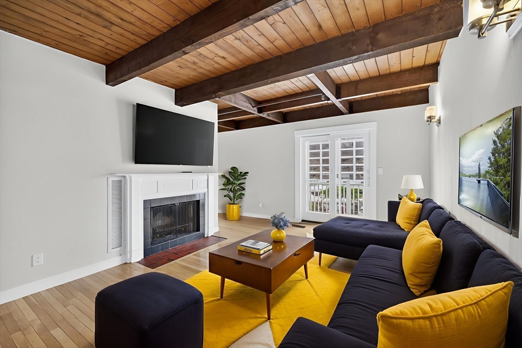 86 Wharf Street, Unit L6 Salem, MA 01970 - Photo 3 of 30 a living room with furniture a flat screen tv and a fireplace