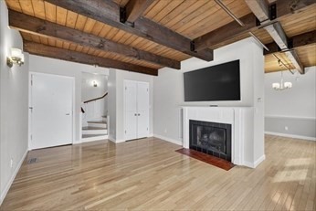 86 Wharf Street, Unit L6 Salem, MA 01970 - Photo 4 of 30 a view of a livingroom with a fireplace a flat screen tv and staircase