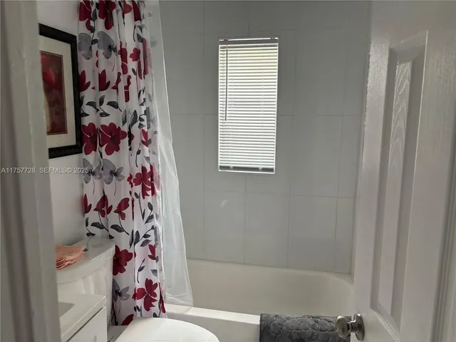 a bathroom with a bathtub and a shower curtain