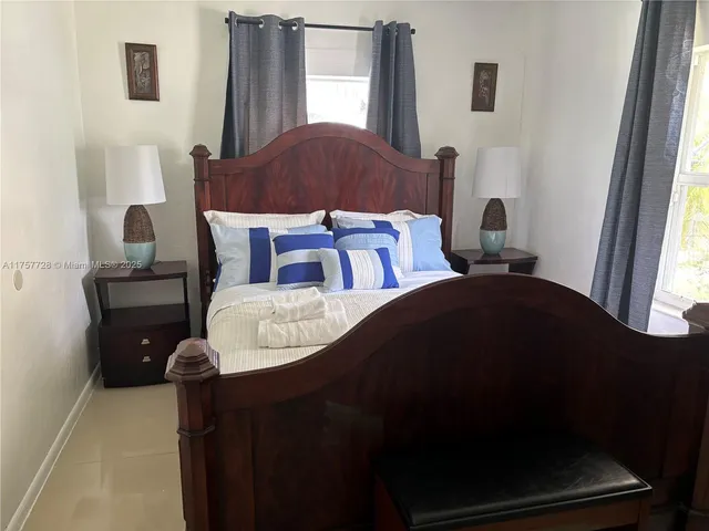 a bed sitting in a bedroom next to a window