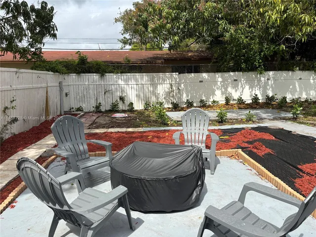 a view of a patio with table and chairs and potted plants