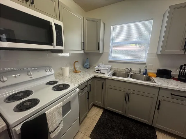 a kitchen with a sink stove top oven and cabinets