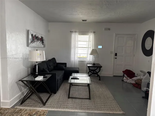 a living room with furniture a rug and a window
