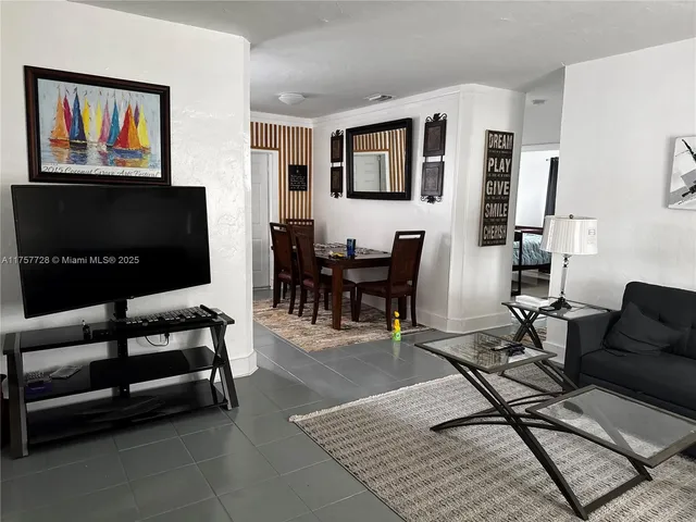 a living room with furniture a piano and a flat screen tv