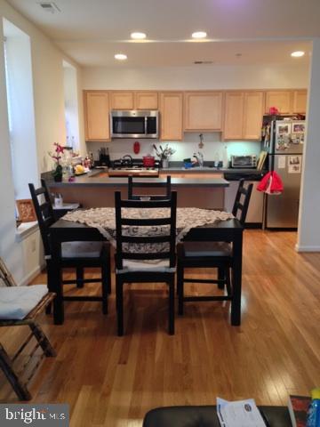 a kitchen with a table chairs a sink dishwasher and cabinets