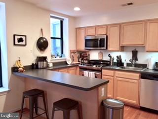2627 Adams Mill Road Northwest, Unit 102 Washington, DC 20009 - Photo 3 of 9 a kitchen with a sink cabinets and window