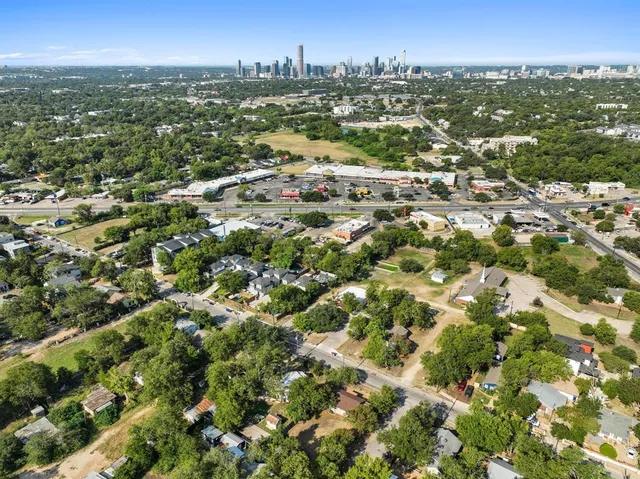 an aerial view of residential houses with city view