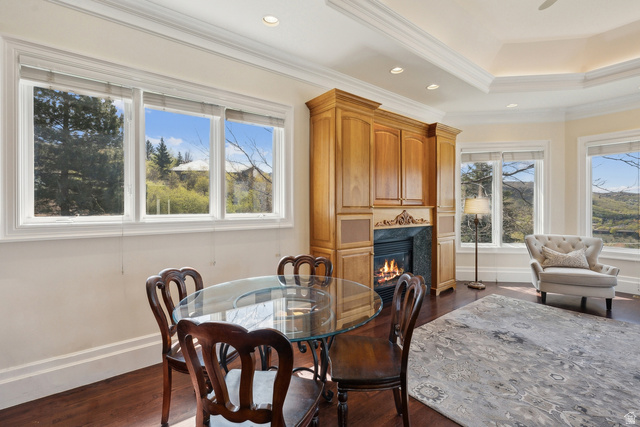 1714 Ridge Point Drive Bountiful, UT 84010 - Photo 40 of 132 Wood-finish flooring with a gas fireplace featuring a stone surround and wood cabinetry, crown molding, and large windows