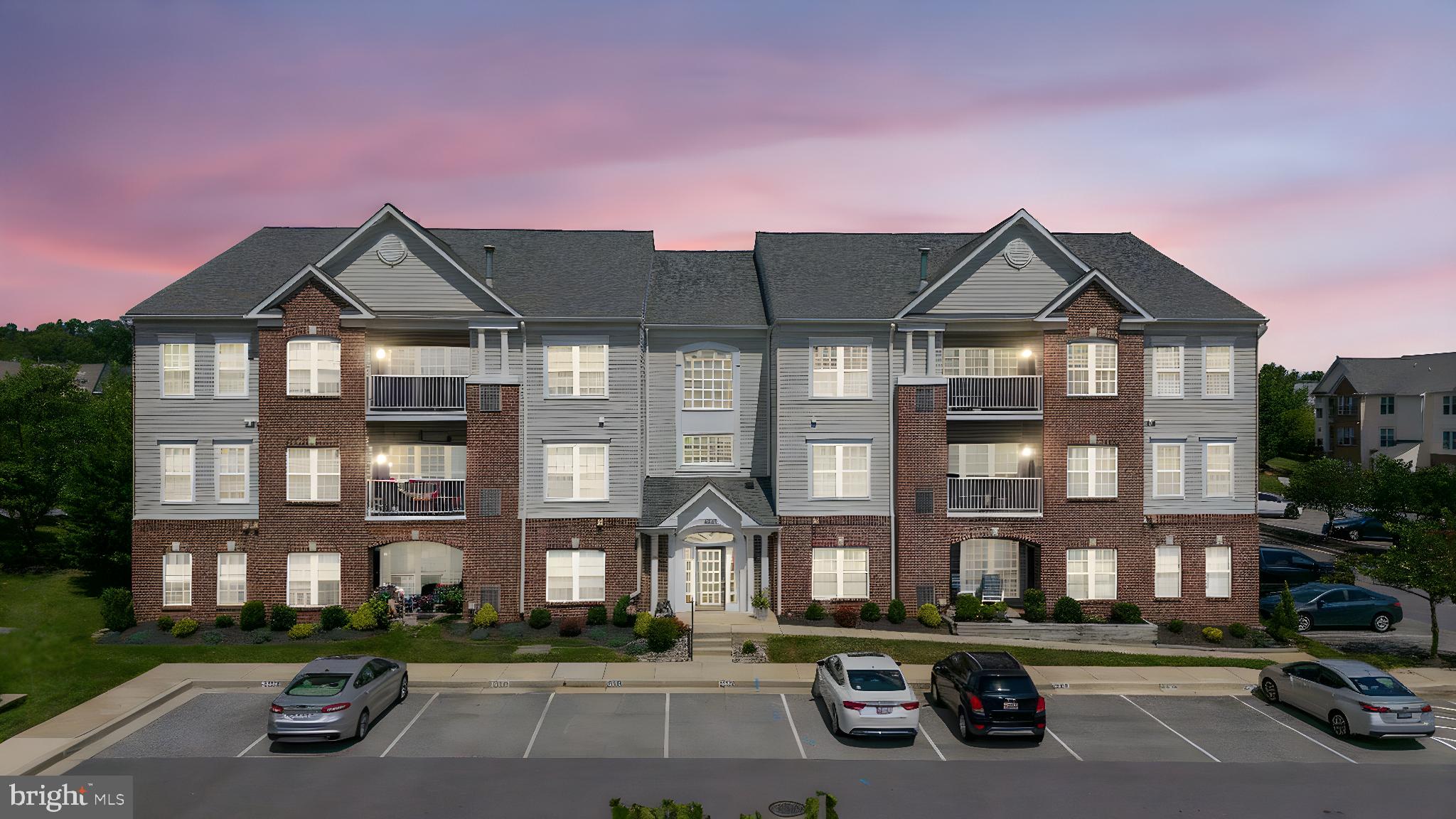 a front view of a house with yard and parking