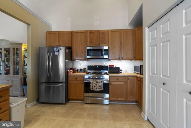 a kitchen with stainless steel appliances granite countertop a refrigerator and a stove top oven