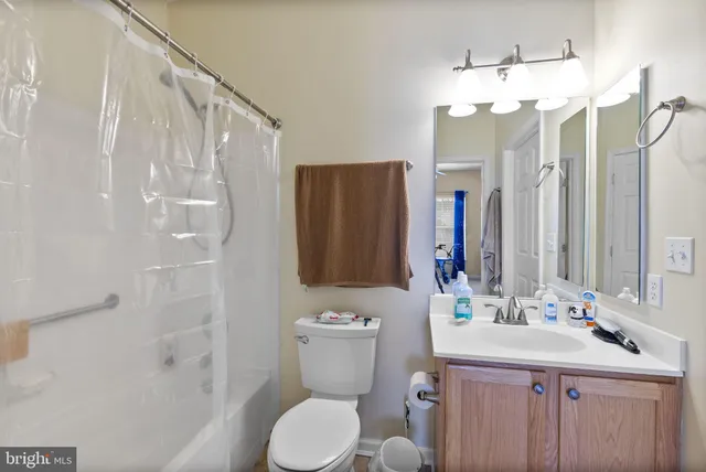 a bathroom with a sink a toilet a mirror a vanity and shower