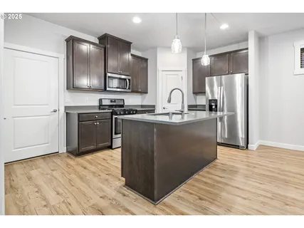 a kitchen with stainless steel appliances granite countertop a refrigerator a sink a stove and oven