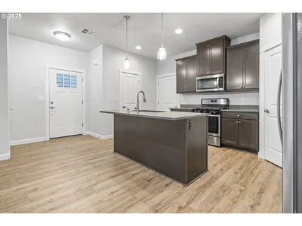 a kitchen with stainless steel appliances granite countertop a sink a stove and a refrigerator