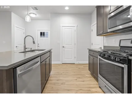 a kitchen with stainless steel appliances granite countertop a sink stove and cabinets