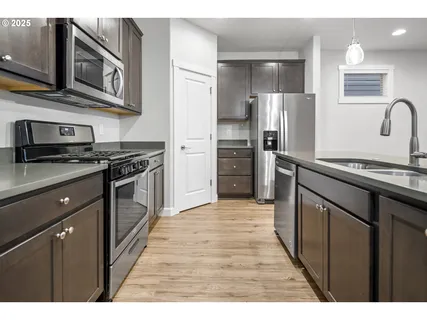 a kitchen with stainless steel appliances granite countertop a stove refrigerator and cabinets