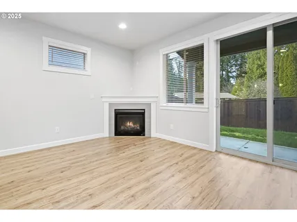 a view of empty room with wooden floor and fireplace