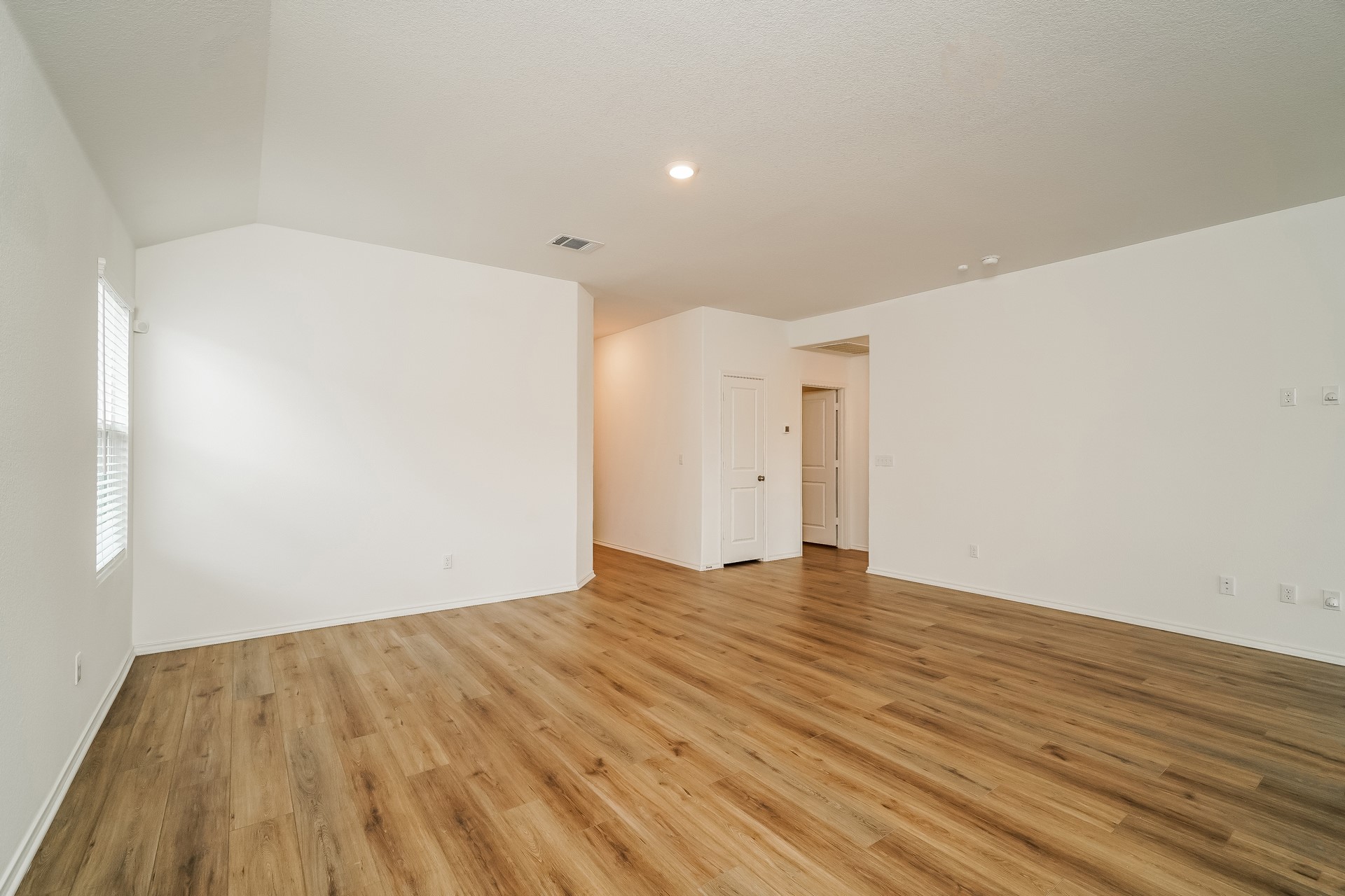 341 Madrid Kyle, TX 78640 - Photo 12 of 27 An airy living space features warm wood flooring and ample natural light.