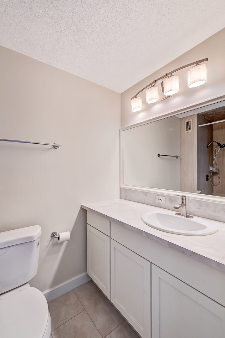 2211 South Highland Avenue, Unit 3E Lombard, IL 60148 - Photo 21 of 25 a bathroom with a toilet sink and mirror