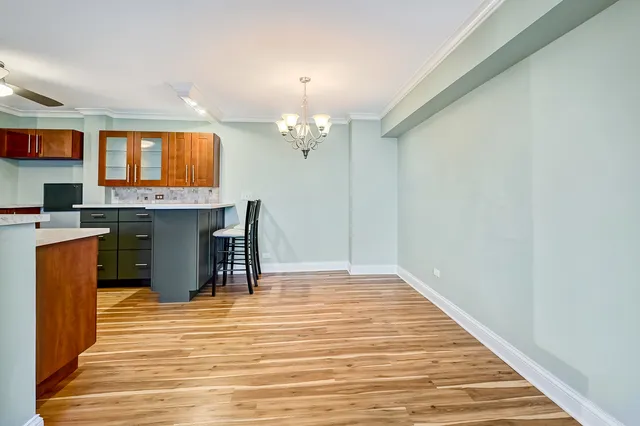 a dining room with kitchen island stainless steel appliances a stove and a chandelier