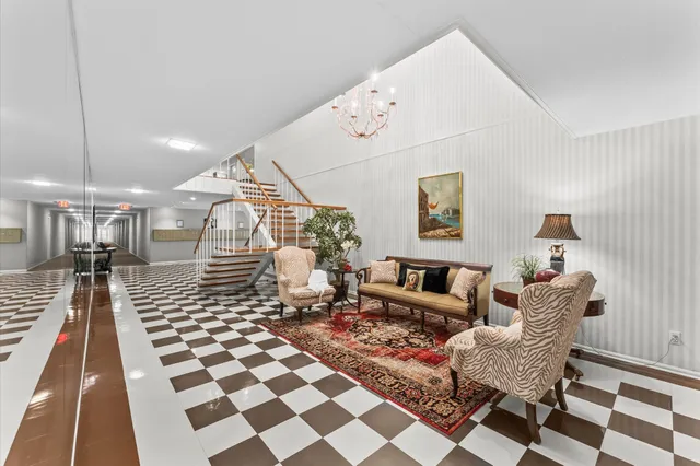 a living room with a black white checkered floor with couches and a rug