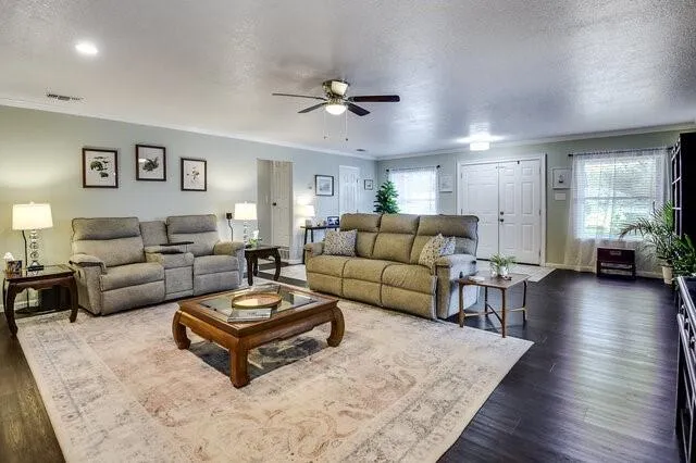 a living room with furniture and a wooden floor