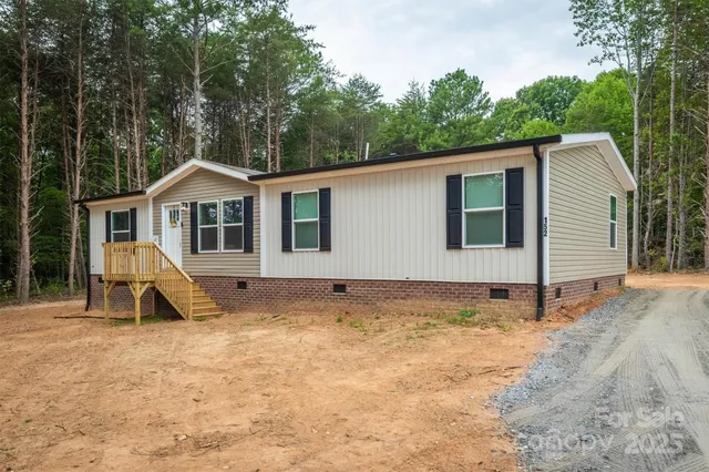 a view of a house with backyard and trees