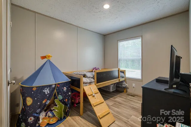 a living room with furniture a flat screen tv and a window