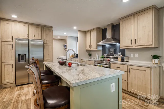 a kitchen with kitchen island granite countertop a sink a counter space stainless steel appliances and cabinets