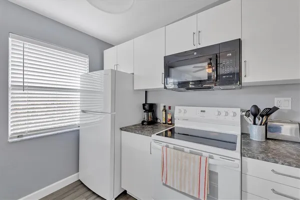 a kitchen with stainless steel appliances granite countertop a sink stove and microwave