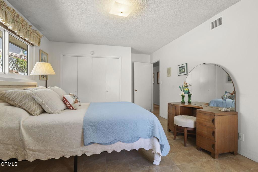 4907 Island View Street Oxnard, CA 93035 - Photo 26 of 44 a bedroom with a bed a mirror and lamp