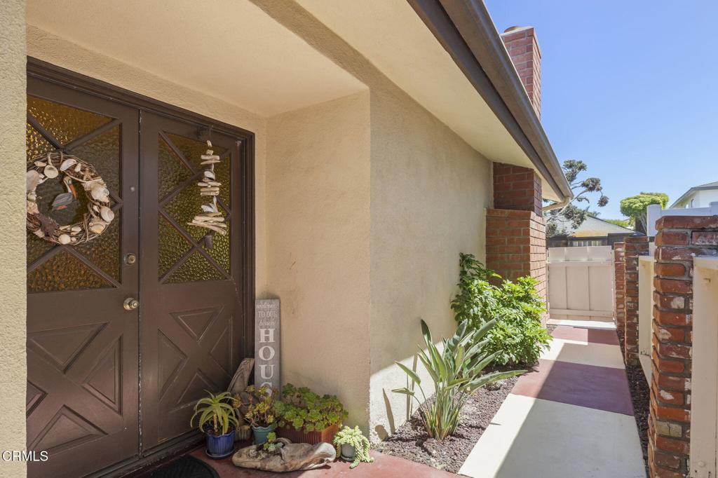 4907 Island View Street Oxnard, CA 93035 - Photo 10 of 44 a vase with flowers sitting on a floor in front of a door