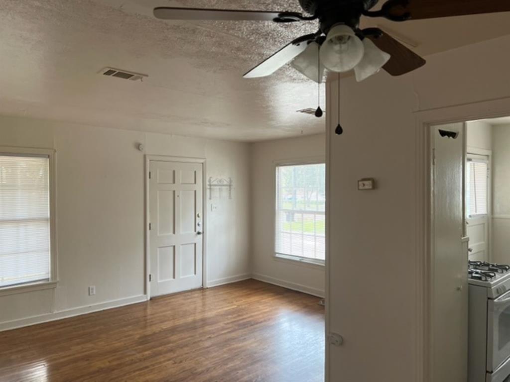 1407 Bolivar Street Denton, TX 76201 - Photo 2 of 4 wooden floor in an empty room with a window