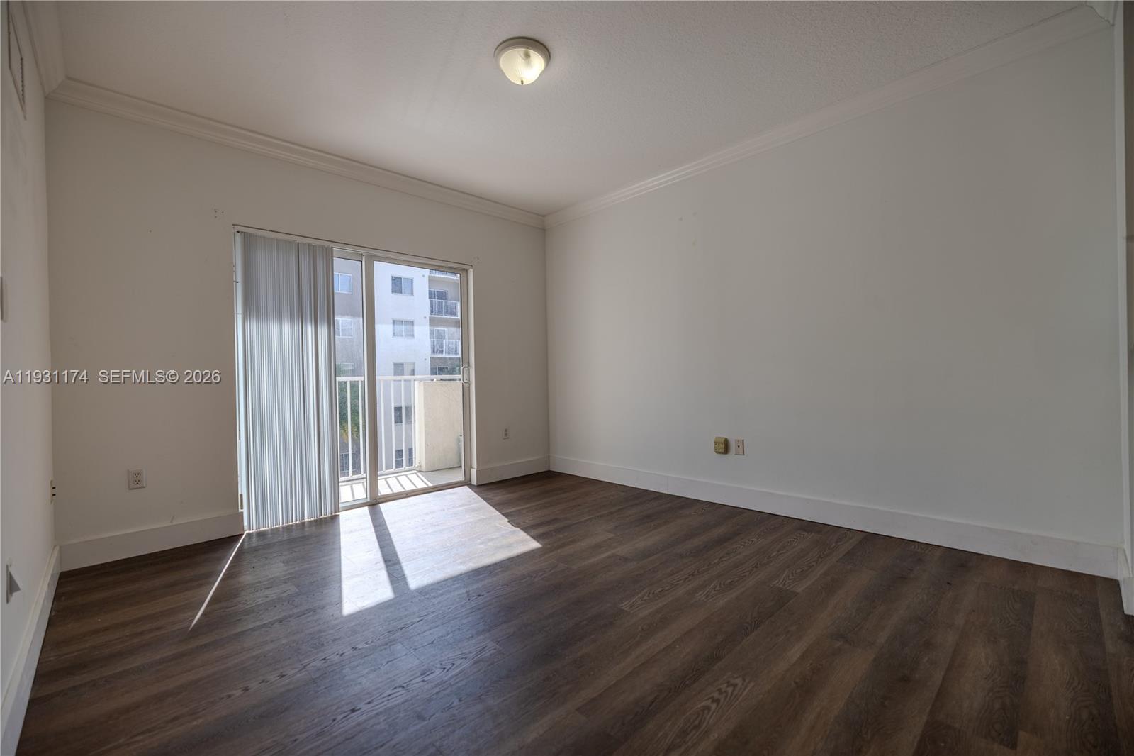 11050 Southwest 196th Street, Unit 305 Cutler Bay, FL 33157 - Photo 4 of 22 an empty room with wooden floor and windows