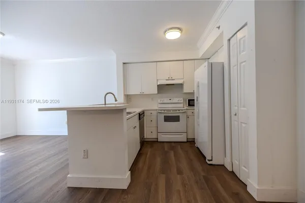 a kitchen with cabinets a sink and wooden floor