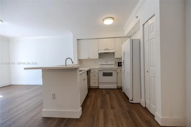 a kitchen with cabinets a sink and wooden floor