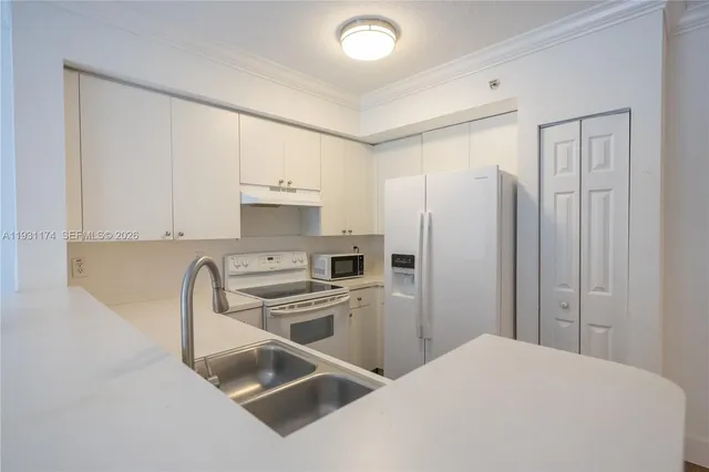 a kitchen with stainless steel appliances a refrigerator sink and white cabinets