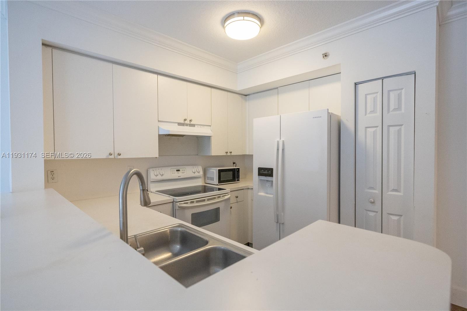 11050 Southwest 196th Street, Unit 305 Cutler Bay, FL 33157 - Photo 6 of 22 a kitchen with stainless steel appliances a refrigerator sink and white cabinets