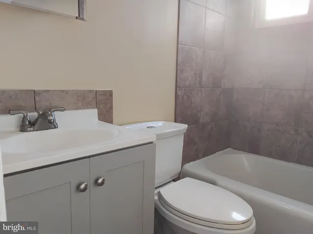 a bathroom with a white bath tub and a toilet
