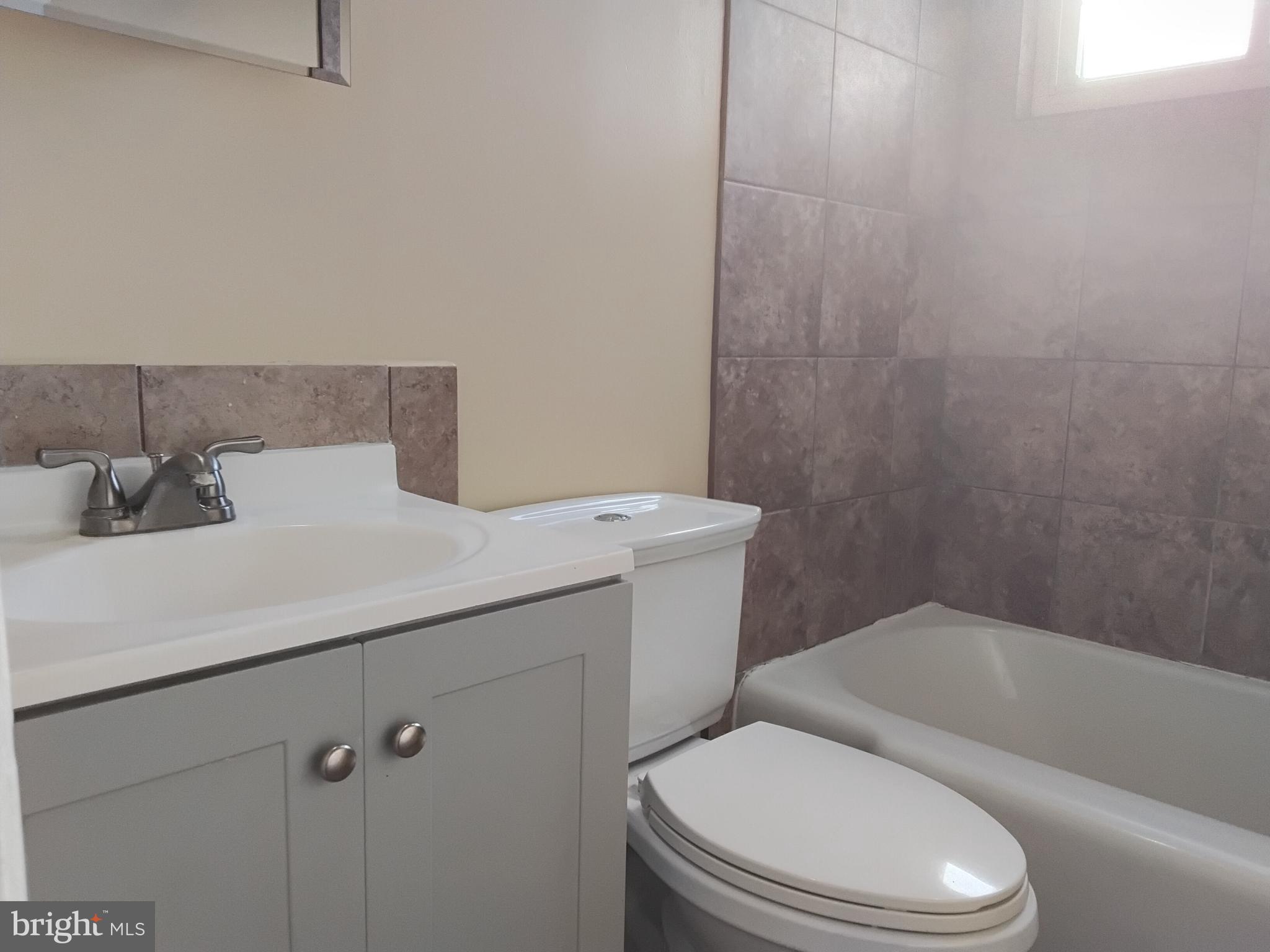 3867 26th Avenue Temple Hills, MD 20748 - Photo 14 of 27 a white toilet sitting next to a bathroom sink