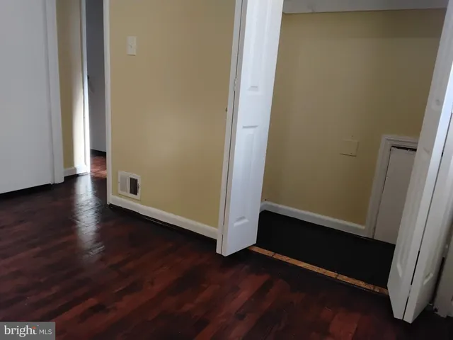 an empty room with wooden floor and closet