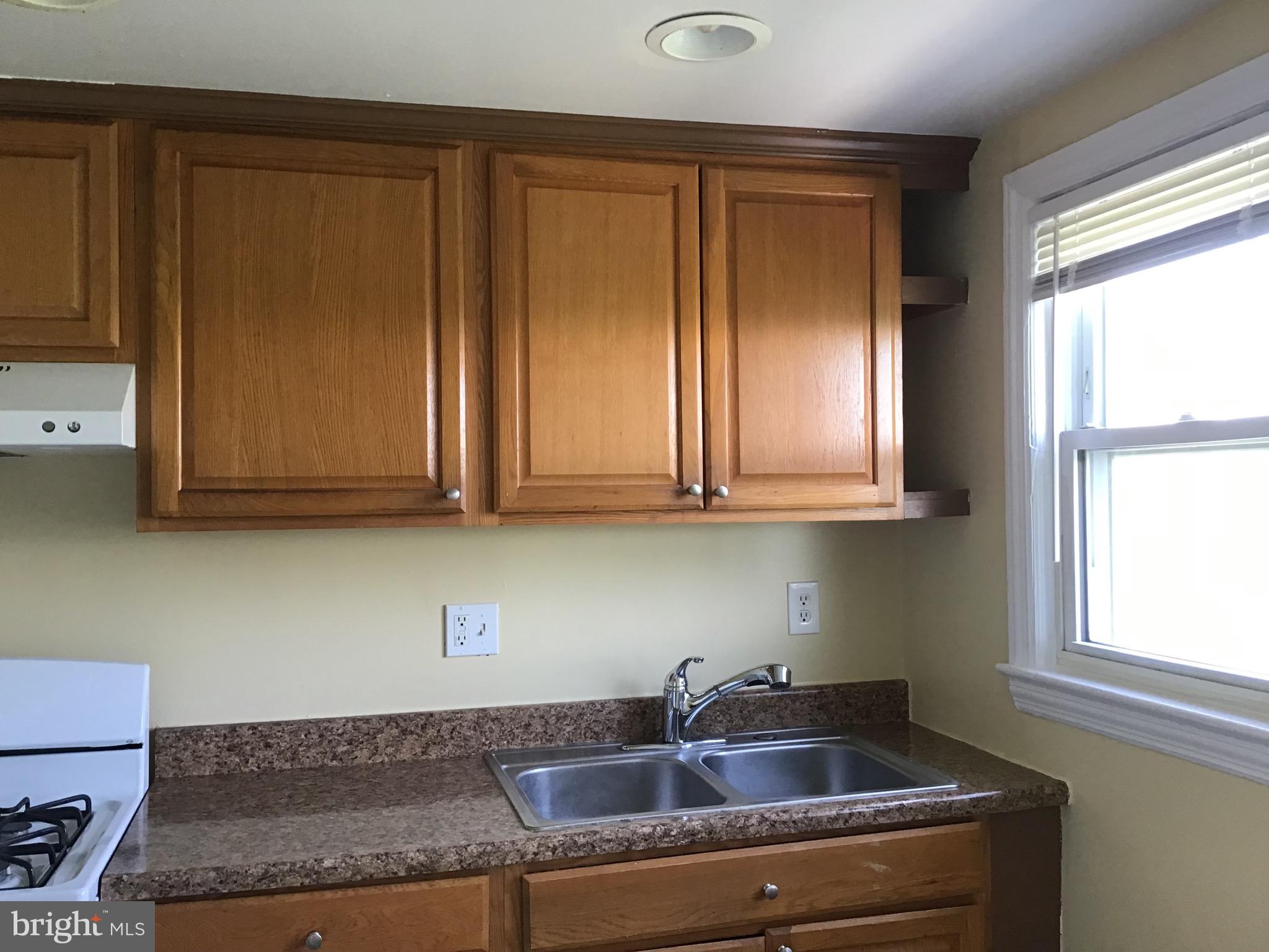 3867 26th Avenue Temple Hills, MD 20748 - Photo 10 of 27 a kitchen with granite countertop cabinets sink and window