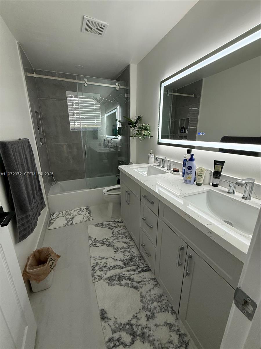 18610 Southwest 39th Court Miramar, FL 33029 - Photo 21 of 32 a bathroom with a double vanity sink a mirror and shower