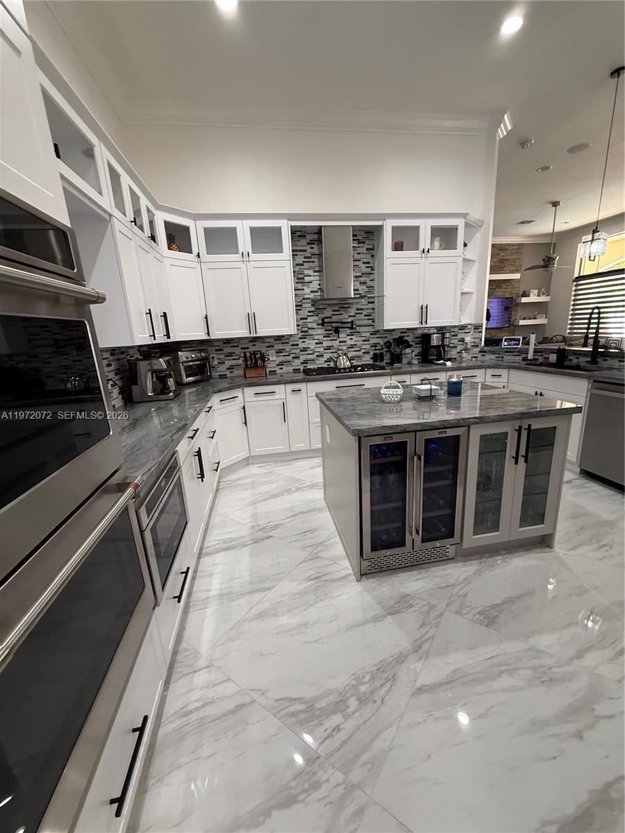 18610 Southwest 39th Court Miramar, FL 33029 - Photo 23 of 32 a kitchen with stainless steel appliances granite countertop a stove a sink and a refrigerator