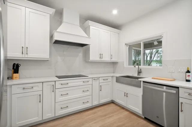 a kitchen with cabinets stainless steel appliances and a window