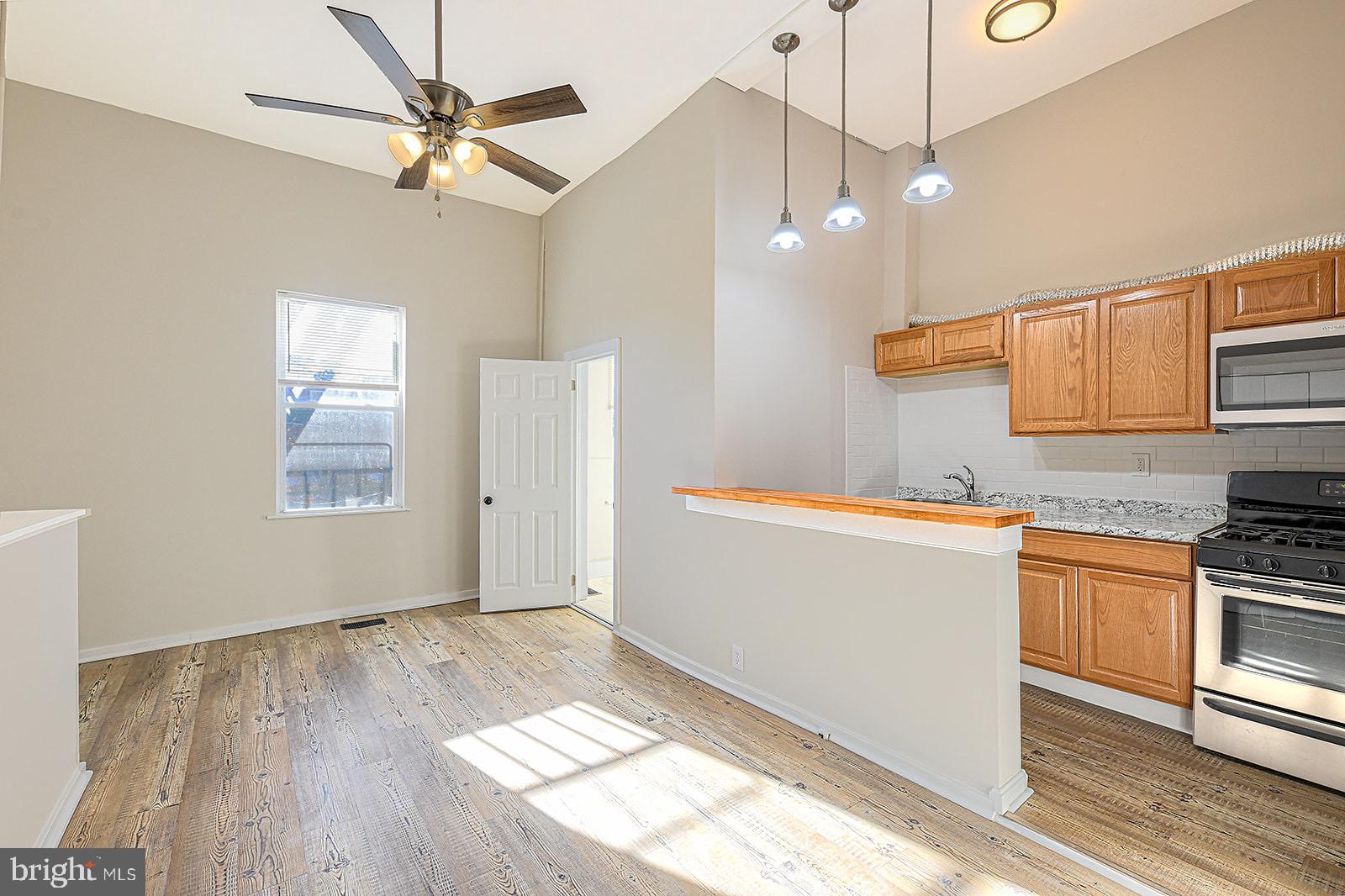 1908 McCulloh Street Baltimore, MD 21217 - Photo 7 of 40 a kitchen with granite countertop wooden floors and white cabinets