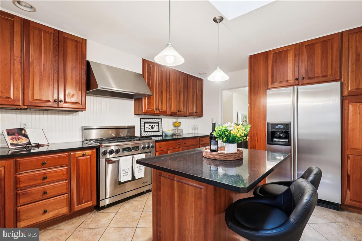 12145 Stirrup Road Reston, VA 20191 - Photo 32 of 80 a kitchen with stainless steel appliances granite countertop a stove a refrigerator and a wooden cabinets
