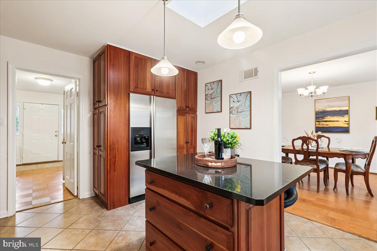 12145 Stirrup Road Reston, VA 20191 - Photo 34 of 80 a kitchen with granite countertop a table chairs and refrigerator