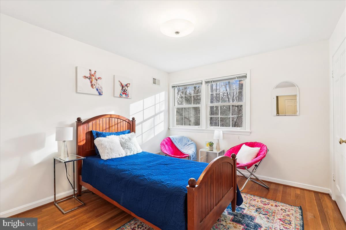 12145 Stirrup Road Reston, VA 20191 - Photo 54 of 80 a bedroom with a bed and a wooden floor