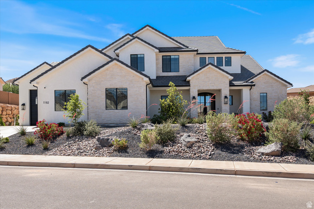 1192 East Corral Way Washington, UT 84780 - Photo 3 of 81 Modern stucco and stone exterior featuring multiple gables, black-frame windows, and a black tile roof