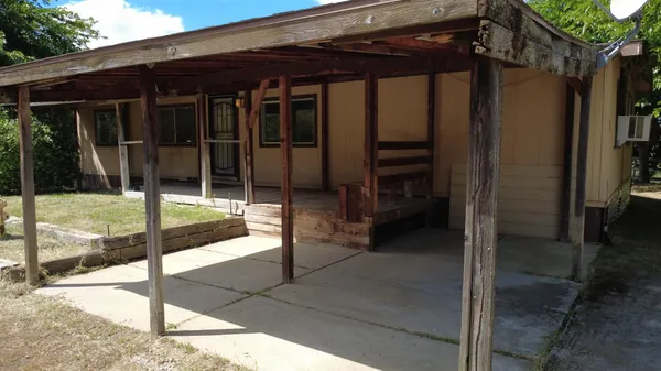 a backyard of a house with table and chairs